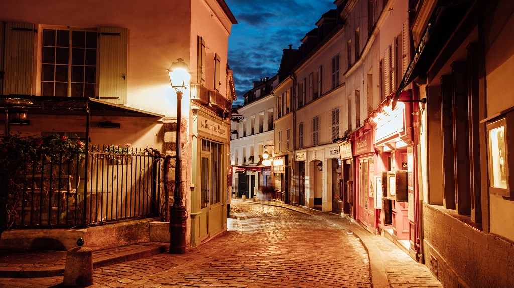 Illuminated streets of Monmartre quarter, street in Paris at night