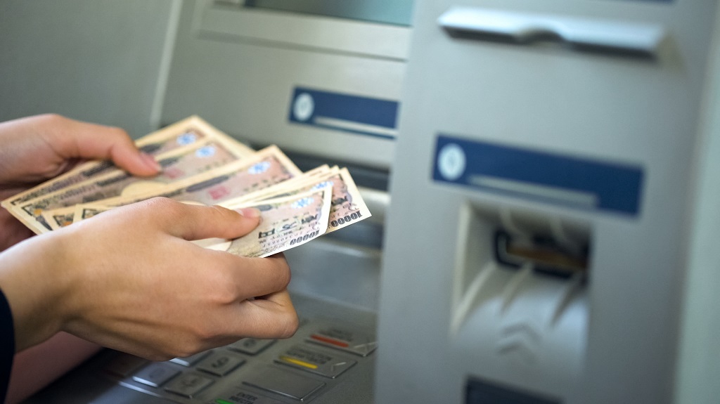 Woman counting Japanese Yen withdrawn from ATM, 24 hours service, easy banking Woman counting Japanese Yen withdrawn from ATM, 24 hours service, easy banking